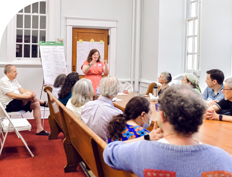 woman at the front of a classroom teaching a class