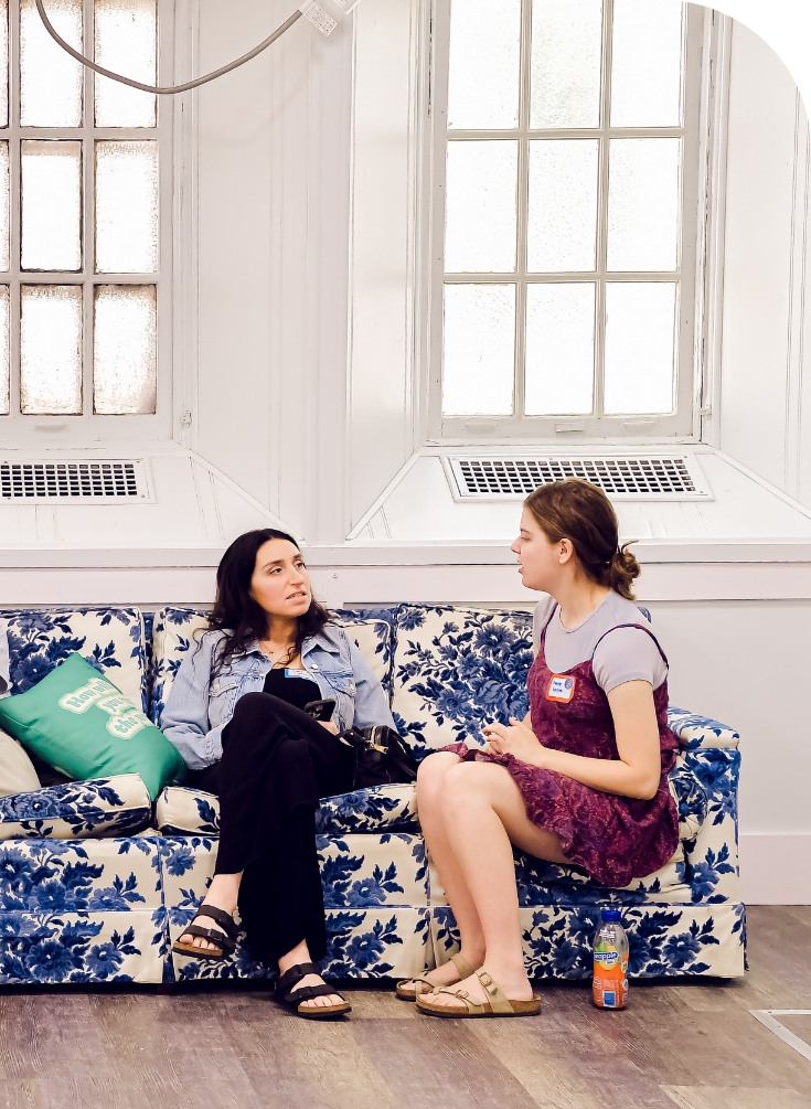 two women talking on a couch