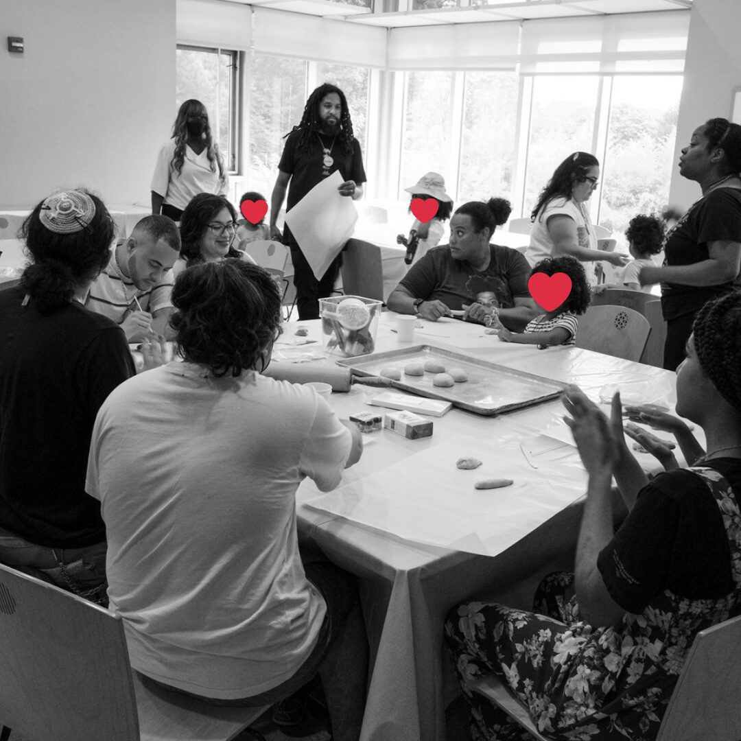 B&W photo of Jews of Color seated around a table, talking